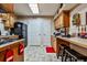 Well-lit kitchen featuring wooden cabinets, black appliances, breakfast bar and tile flooring at 1137 Maple Creek Rdg, Loganville, GA 30052