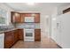 A well-lit kitchen features wood cabinets, white appliances, and a tile backsplash at 1173 Huntington Place Cir, Lithonia, GA 30058