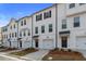 Row of new construction townhomes featuring white siding, black accents, and one car garages at 3220 Bateman Se Dr, Atlanta, GA 30354