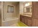 Bathroom showcasing a soaking tub and a dark-wood vanity with a granite countertop and built-in cabinets at 500 Nicole Se Ct, Conyers, GA 30094