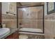 Bathroom features tub with glass doors, tile accents, framed art, and oil rubbed bronze fixtures at 500 Nicole Se Ct, Conyers, GA 30094
