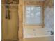 Bathroom with tub and shower, features modern fixtures and a window for natural light at 500 Nicole Se Ct, Conyers, GA 30094