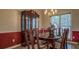 Traditional dining room with a glass-top table, wooden chairs, and a classic china cabinet by the window at 500 Nicole Se Ct, Conyers, GA 30094