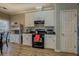 Well-lit kitchen with classic white cabinetry, black appliances, and convenient side-door access at 500 Nicole Se Ct, Conyers, GA 30094