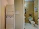 Practical laundry area with a stacked washer and dryer, located adjacent to the wallpapered powder room at 500 Nicole Se Ct, Conyers, GA 30094