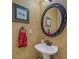 A compact powder room features a pedestal sink and ornate details, including a decorative mirror and wallpaper at 500 Nicole Se Ct, Conyers, GA 30094