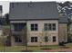 Home's rear exterior with a covered porch, multiple windows, and a well-maintained lawn at 2235 Windsor Bluffs Dr, Cumming, GA 30041