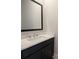 Powder bath boasts a modern black vanity with white quartz countertops and a sleek, dark-framed mirror at 2235 Windsor Bluffs Dr, Cumming, GA 30041