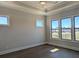 This bedroom features tray ceilings, multiple windows, and beautiful hardwood floors at 2235 Windsor Bluffs Dr, Cumming, GA 30041