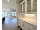 Butler's pantry features white cabinets, glass front shelving, and quartz countertops, flowing into open living space at 2235 Windsor Bluffs Dr, Cumming, GA 30041