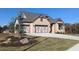 Craftsman-style home featuring a three-car garage, brick facade, and manicured front lawn at 2235 Windsor Bluffs Dr, Cumming, GA 30041