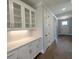 Hallway features shaker doors, modern lighting and white butler's pantry flowing into the entry door at 2235 Windsor Bluffs Dr, Cumming, GA 30041