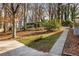 Grassy backyard with mature trees, a stone walkway, and partially shaded area near deck at 2436 Elmwood Se Cir, Atlanta, GA 30339