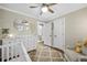 Bright Bedroom featuring a white crib, dresser, and chair, complemented by a ceiling fan at 2436 Elmwood Se Cir, Atlanta, GA 30339