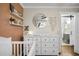Well-lit Bedroom with a white dresser, decorative shelves, and an open doorway to the bathroom at 2436 Elmwood Se Cir, Atlanta, GA 30339