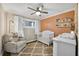 Charming Bedroom with a white crib, accent wall, plush chair, and ample natural light at 2436 Elmwood Se Cir, Atlanta, GA 30339