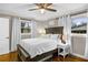 Cozy bedroom with natural light, a ceiling fan, two windows with curtains, and hardwood floors at 2436 Elmwood Se Cir, Atlanta, GA 30339