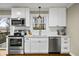 Well-lit kitchen showcasing stainless steel appliances, white cabinets, a subway tile backsplash, and hardwood flooring at 2436 Elmwood Se Cir, Atlanta, GA 30339