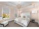 Serene bedroom features a tufted headboard, modern chandelier, and comfortable seating area by the window at 304 Stonemont Dr, Atlanta, GA 30305