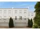 Stunning exterior view of white townhomes with private garage, highlighted by lush greenery at 304 Stonemont Dr, Atlanta, GA 30305