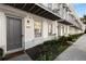 Charming townhome entrance featuring a gray door, manicured landscaping, and a brick facade at 304 Stonemont Dr, Atlanta, GA 30305