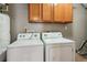 Laundry room with a washing machine and dryer and overhead cabinets at 3510 Riviera Dr, Cumming, GA 30041