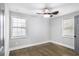 This bedroom features hardwood floors, gray walls, two windows with wood blinds, and a ceiling fan with lighting at 1459 Kenilworth Sw Dr, Atlanta, GA 30310
