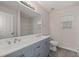 Bathroom boasts a double sink vanity with blue cabinets, large mirror and neutral paint at 131 Ellis Dr, Conyers, GA 30012