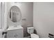 Clean half bathroom with a pedestal sink, round mirror, and neutral gray walls at 131 Ellis Dr, Conyers, GA 30012