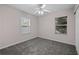 Bedroom features neutral walls, plush carpet, two windows and a ceiling fan with lights at 131 Ellis Dr, Conyers, GA 30012