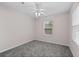 Bedroom features neutral walls, plush carpet, a window and ceiling fan with lights at 131 Ellis Dr, Conyers, GA 30012
