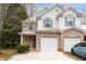 Charming two-story townhome features a brick facade, light siding, attached garage and well-maintained landscaping at 131 Ellis Dr, Conyers, GA 30012
