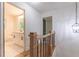 Upstairs hallway featuring wooden railing and view of a well-lit bathroom at 418 Mockingbird, Smyrna, GA 30082