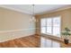 Elegant dining room showcasing hardwood floors, a chandelier, and a large window providing ample natural light at 868 Clarion Way, Lawrenceville, GA 30044