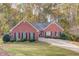Charming one-story red brick home featuring a well-manicured lawn, classic black shutters, and a welcoming driveway at 868 Clarion Way, Lawrenceville, GA 30044