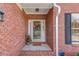 Close-up of a charming red brick home's front porch featuring a decorated glass door and white trim at 868 Clarion Way, Lawrenceville, GA 30044