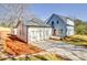 Home exterior featuring a two-car garage, manicured yard, and light blue siding at 3165 Old Jonesboro Rd, Hapeville, GA 30354
