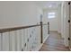 Upper hallway with wood floors features a white railing and trim for classic aesthetic appeal at 3165 Old Jonesboro Rd, Hapeville, GA 30354
