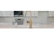 Close up of modern kitchen featuring stainless steel appliances, stone countertops, white cabinetry, and a gold faucet at 3165 Old Jonesboro Rd, Hapeville, GA 30354