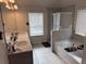 Bright bathroom featuring double sinks, white cabinets, tile flooring, a soaking tub and a glass door shower at 7266 Gladstone Cir, Lithonia, GA 30038