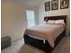 Bedroom with a large window for natural light, neutral carpet, and framed artwork above a dark wood bed frame at 7266 Gladstone Cir, Lithonia, GA 30038