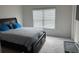 Comfortable bedroom with a large window, grey carpet, and a dark wood bed frame with built-in storage at 7266 Gladstone Cir, Lithonia, GA 30038