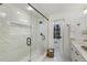 A modern bathroom with marble tiled walls and a frameless glass shower enclosure at 5548 Martina Way, Atlanta, GA 30338