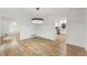 Open concept dining room featuring hardwood floors, a modern light fixture, and access to the kitchen at 5548 Martina Way, Atlanta, GA 30338