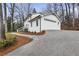 Exterior angle of a stately white brick home with an attached two-car garage and paved driveway at 5548 Martina Way, Atlanta, GA 30338
