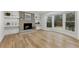 Cozy living room with a brick fireplace, hardwood floors, and a large bay window with wooded views at 5548 Martina Way, Atlanta, GA 30338