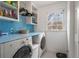 A laundry room featuring a washer, dryer, blue countertop, white cabinets, and a window at 295 Bruton Way, Atlanta, GA 30342