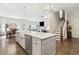 Open kitchen with gray island, farmhouse sink, stainless appliances, hardwood floors and view to stairs and living room at 569 Stone Field Nw Run, Marietta, GA 30060