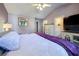 Spacious bedroom with vaulted ceiling, ceiling fan, king bed with purple throw, and TV at 3831 Austin Park Ln, Decatur, GA 30032