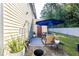 Back patio features outdoor furniture, covered by a large blue umbrella, next to a grassy, fenced-in yard at 3831 Austin Park Ln, Decatur, GA 30032